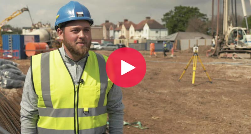Construction worker with blue hart hat on construction site with a Leica iCON total station
